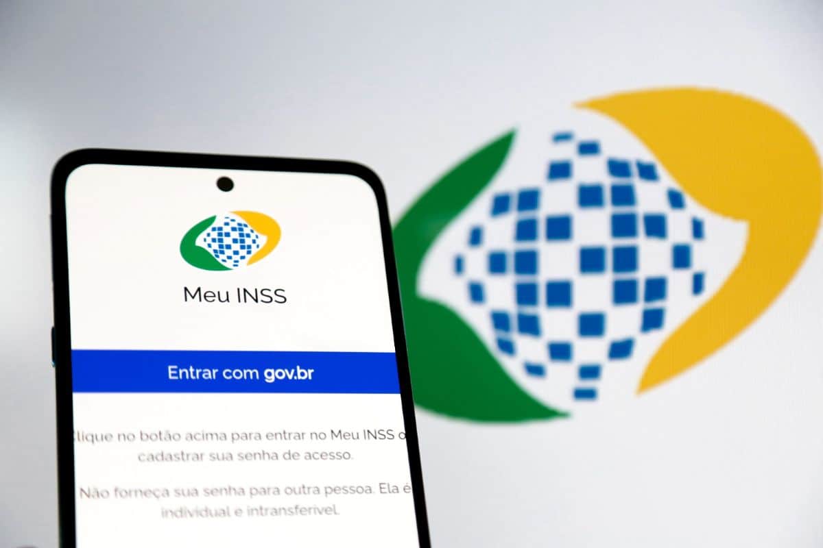 Aplicativo Meu INSS aberto na tela do celular com a opção entrar com gov.br e logo do INSS ao fundo