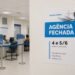 Cartaz de agência fechada no Corpus Christi em parede de sala de atendimento do INSS com guichês numerados ao fundo