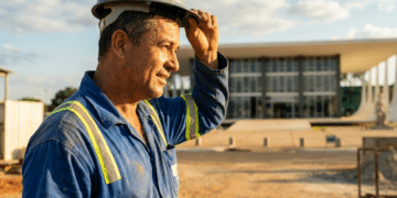 Trabalhador de capacete e uniforme em frente ao prédio do Supremo