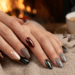 Mãos femininas com unhas amendoadas em esmalte vinho metálico, verde escuro e cinza prateado sobre tecido bege