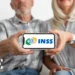 Casal idoso mostra tela de celular com logo do INSS, sentados juntos e sorrindo