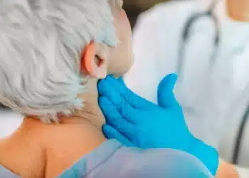 Profissional de saúde examina o pescoço de paciente durante atendimento relacionado à campanha Julho Verde.