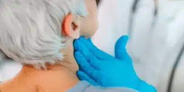 Profissional de saúde examina o pescoço de paciente durante atendimento relacionado à campanha Julho Verde.