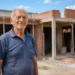 Idoso em frente a imóvel em reforma que representa o projeto Habitação Adaptada 60+.