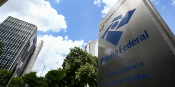 Placa da Receita Federal em frente a prédio público representando o pagamento da restituição do Imposto de Renda.