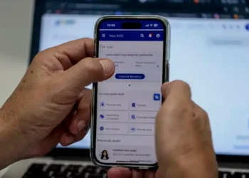 Aposentado acessa o aplicativo Meu INSS pelo celular para consultar serviços e contratar crédito consignado.