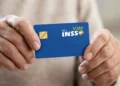 Idoso segurando cartão do Meu INSS Vale+ após encerramento da antecipação de até R$ 450 pelo INSS.