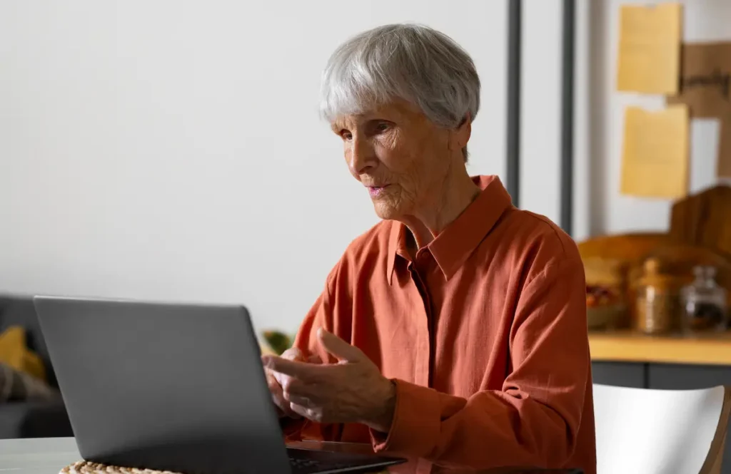 Capacitação digital para idosos e segurança online Idosa utilizando notebook para aprender práticas seguras no ambiente digital.