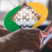 Idosa acessa serviços digitais do INSS pelo celular em ambiente residencial.