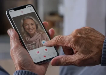 Idoso utilizando aplicativo de relacionamento no celular para conhecer novas pessoas com segurança.