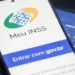 Aplicativo Meu INSS em celular representa o agendamento de perícias médicas e avaliações sociais.