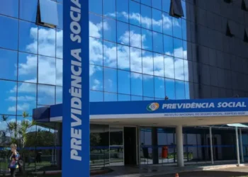 Fachada da sede do INSS com letreiro Previdência Social em destaque.