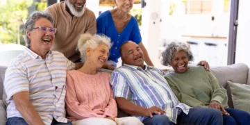 Grupo de pessoas idosas reunidas e sorrindo durante momento de convivência e lazer.