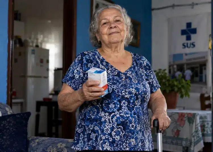 Pessoa idosa segura medicamentos e utiliza bengala em referência aos direitos garantidos pelo Estatuto da Pessoa Idosa no SUS.