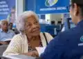 Idosa com mais de 80 anos sendo atendida em órgão público, representando a prioridade especial garantida a esse grupo.