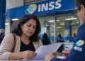 Mulher conferindo documentos durante atendimento no INSS, representando o processo de revisão da aposentadoria.